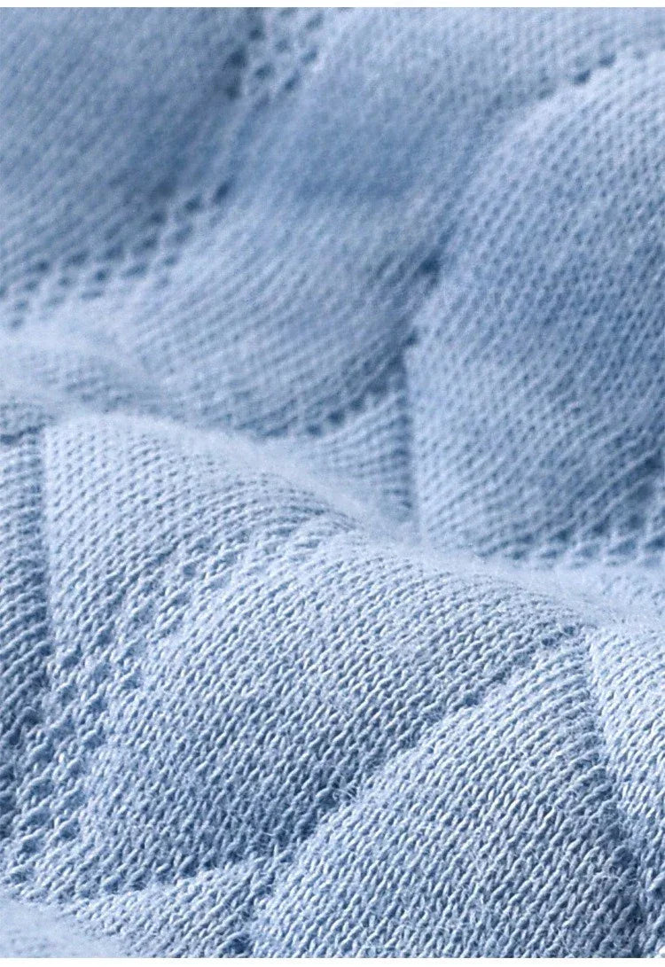 Light blue knitted cotton fabric detail of a warm baby romper