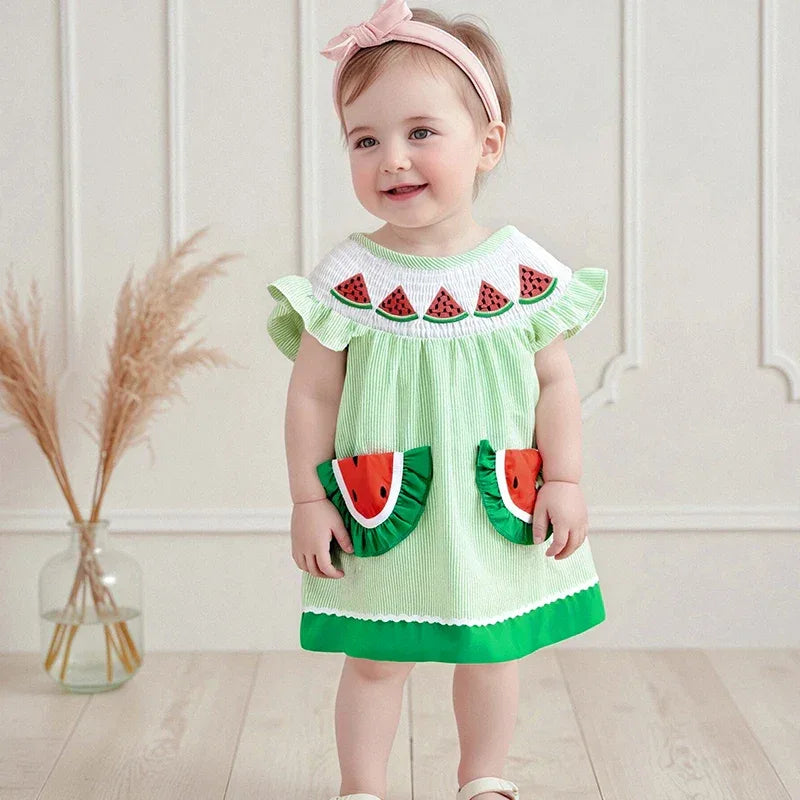 toddler girl wearing green and white watermelon baby dress with ruffled sleeves and watermelon pockets