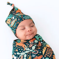 Baby wearing The SoftKnot Cap in Wild West print, a cozy bamboo newborn cap with a knot.