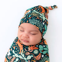 Baby wearing The SoftKnot Cap Wild West bamboo newborn hat with soft, snug, non-scratch fit.