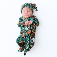 Newborn asleep in The SoftKnot Cap Wild West print, bamboo knot cap with vibrant design.