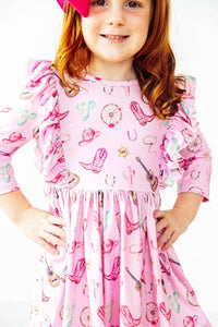 young girl wearing pink western dress for girls with ruffled sleeves smiling and posing