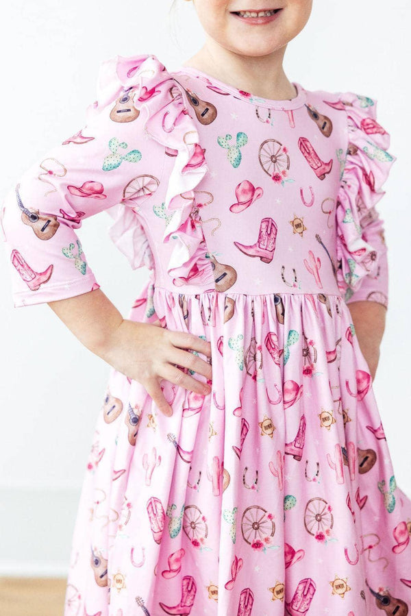 Young girl wearing pink western dress for girls with twirl ruffle sleeves smiling with hands on hips