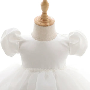 white baby girl tulle dress with puff sleeves and pearl waist detail for infants