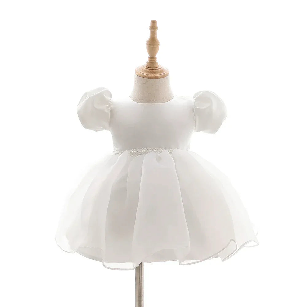 white baby girl tulle dress with puff sleeves and pearl waist detail for infants