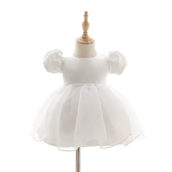 white baby girl tulle dress with puff sleeves and pearl waist detail for infants