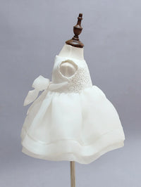White chiffon baby dress set displayed on a mannequin showing delicate lace bodice and bow detail