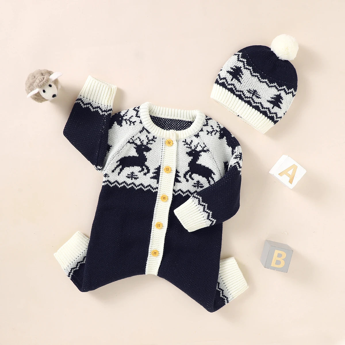 Navy and white winter knit rompers for babies with reindeer pattern and matching pom pom hat