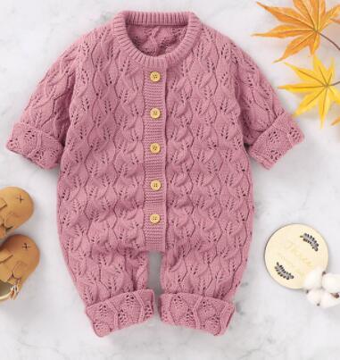 pink knitted winter romper for babies with wooden buttons and long sleeves
