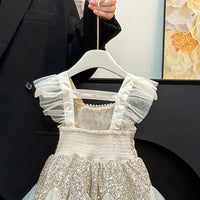 baby cream sequin party dress with ruffled sleeves hanging on hanger
