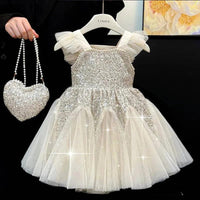 baby white sequin party dress with tulle skirt and ruffled straps displayed on hanger with matching heart-shaped purse