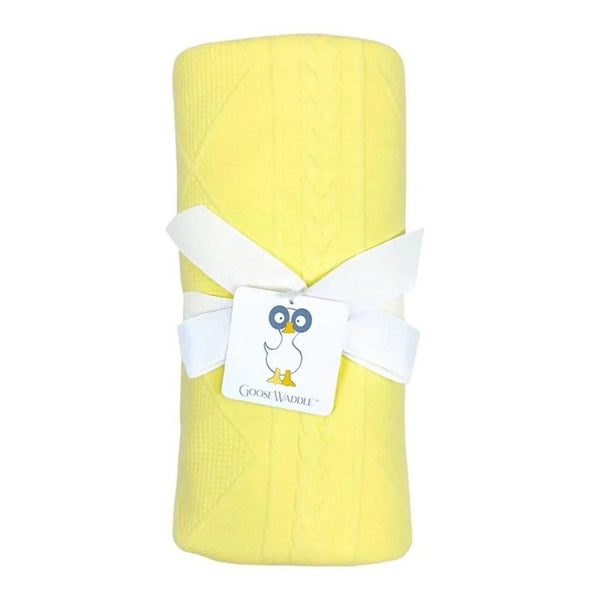rolled yellow knit baby blanket for newborns with white ribbon and Goosewaddle tag