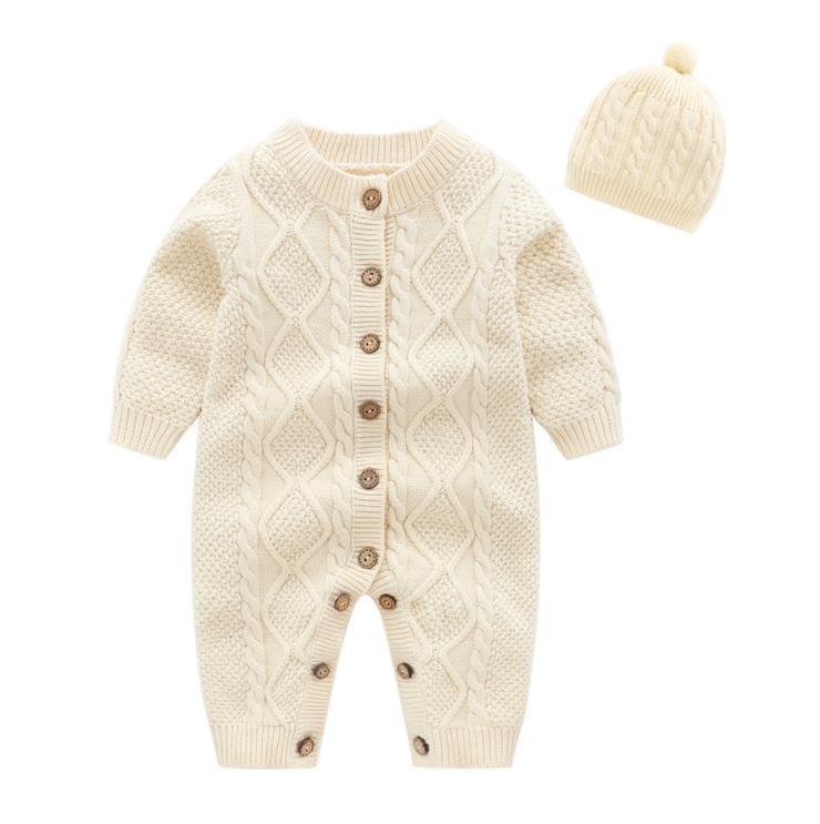 Cream knitted baby romper set for infants with cable knit pattern and matching pom pom hat