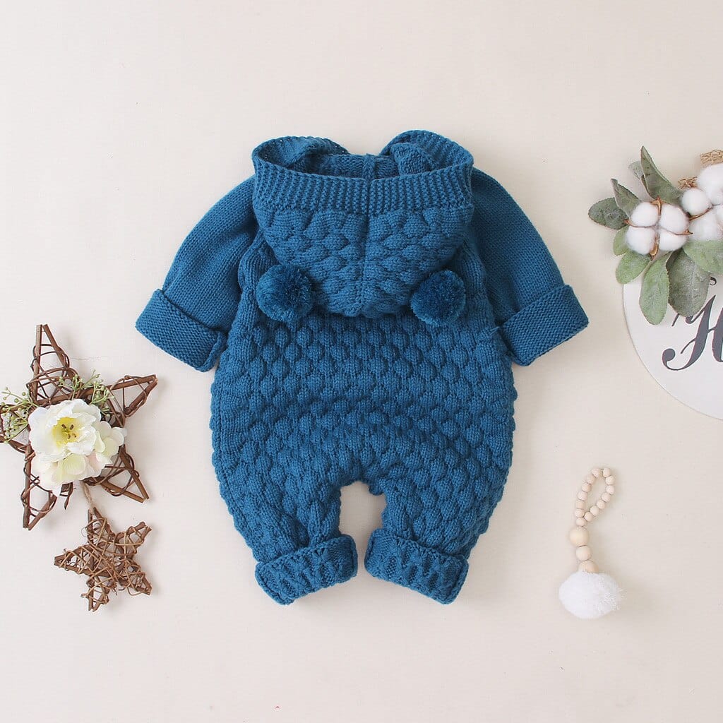 blue hooded knitted romper for babies with pom pom details and textured knit pattern