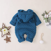 blue hooded knitted romper for babies with pom pom details and textured knit pattern