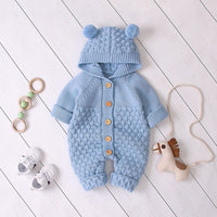 Baby blue hooded knitted romper for babies with pom pom ears and wooden buttons, suitable for infants