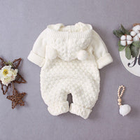 Cream hooded knitted romper for babies with pom pom details and long sleeves
