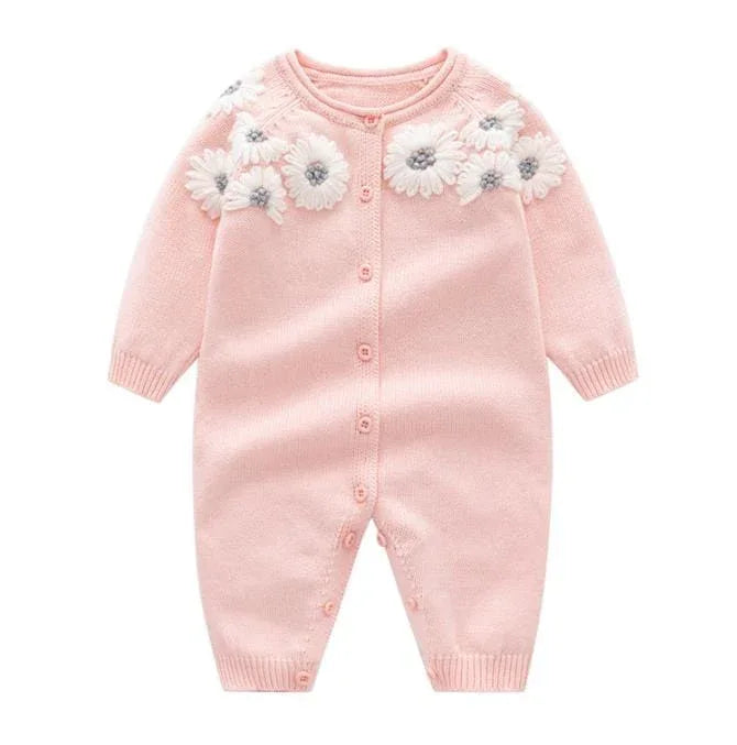 Pink knitted baby romper for infants with white floral applique and long sleeves