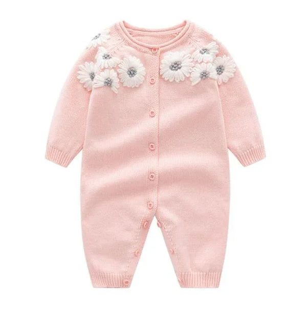 Pink knitted baby romper for infants with white floral applique and long sleeves