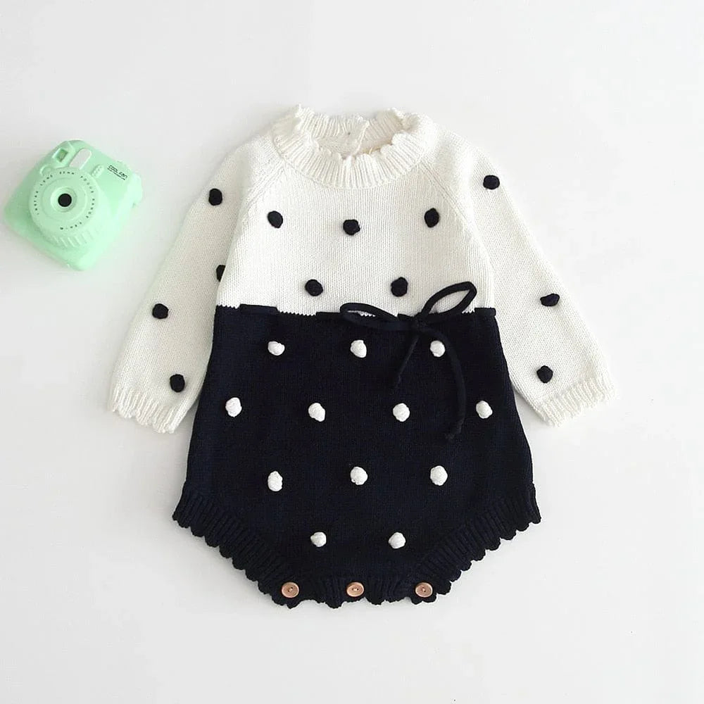 Black and white knitted baby romper with ruffles and polka dots for newborns with long sleeves
