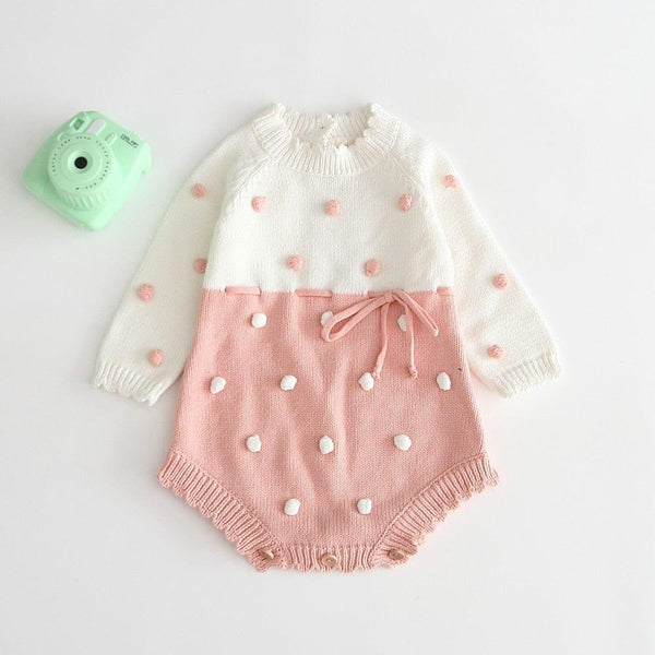 Knitted baby romper with ruffles in white and pink for infants with pom pom detailing